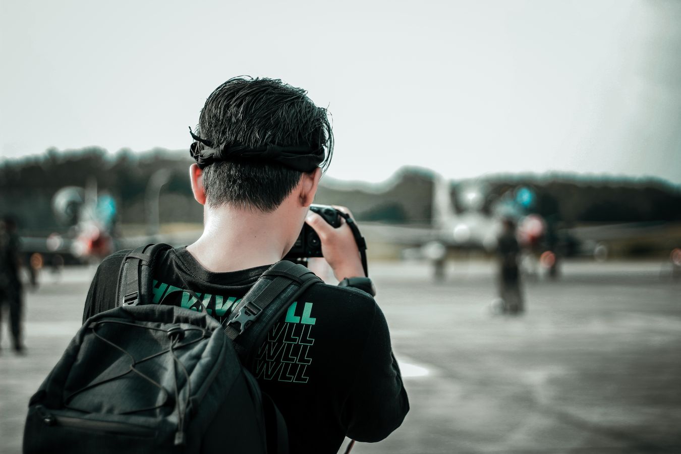 Photographe avec sac a dos et appareil photo sur le tarmac pres d un avion