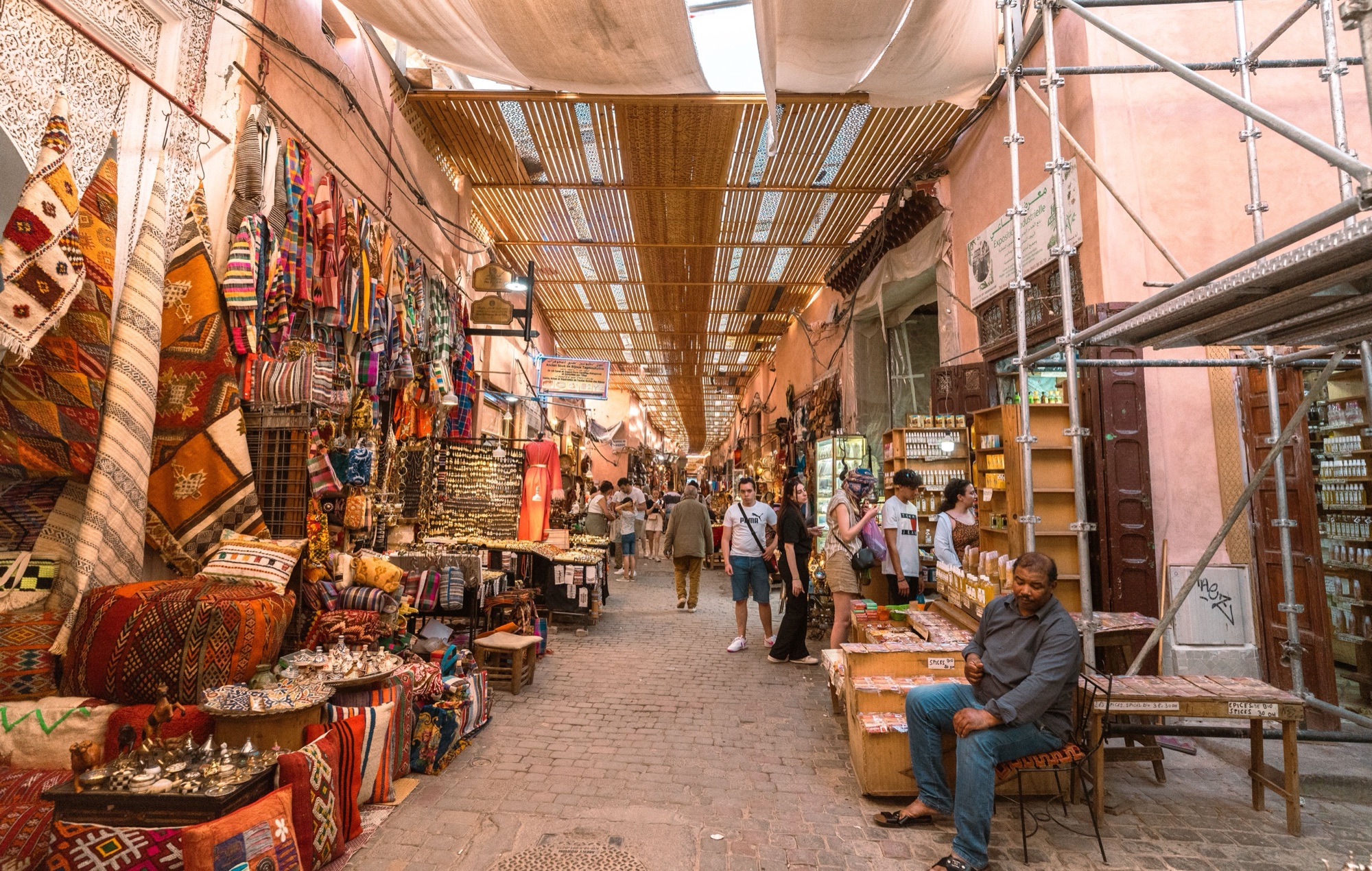 souk animé dans la médina de Marrakech, étals colorés et ruelle piétonne