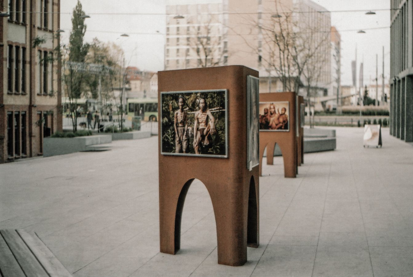 Installations photographiques exposées en extérieur sur structures, dans un espace public arboré