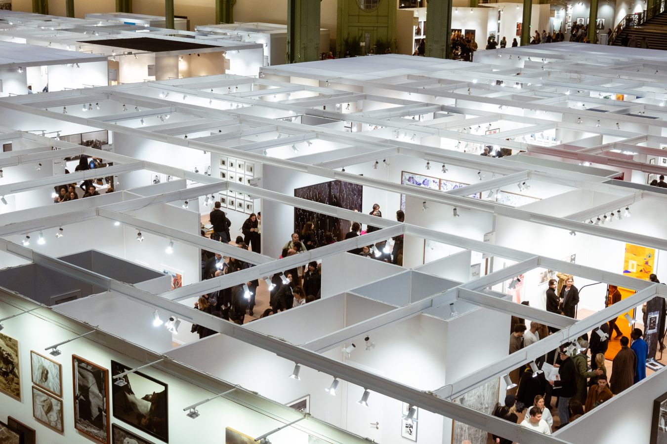 Vue en hauteur des stands de galeries et visiteurs a la foire Paris Photo sous la verriere