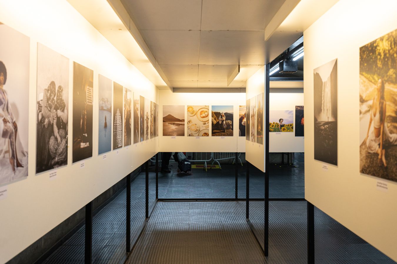 Corridor d'exposition avec tirages photographiques accroches sur les murs, festival de photographie