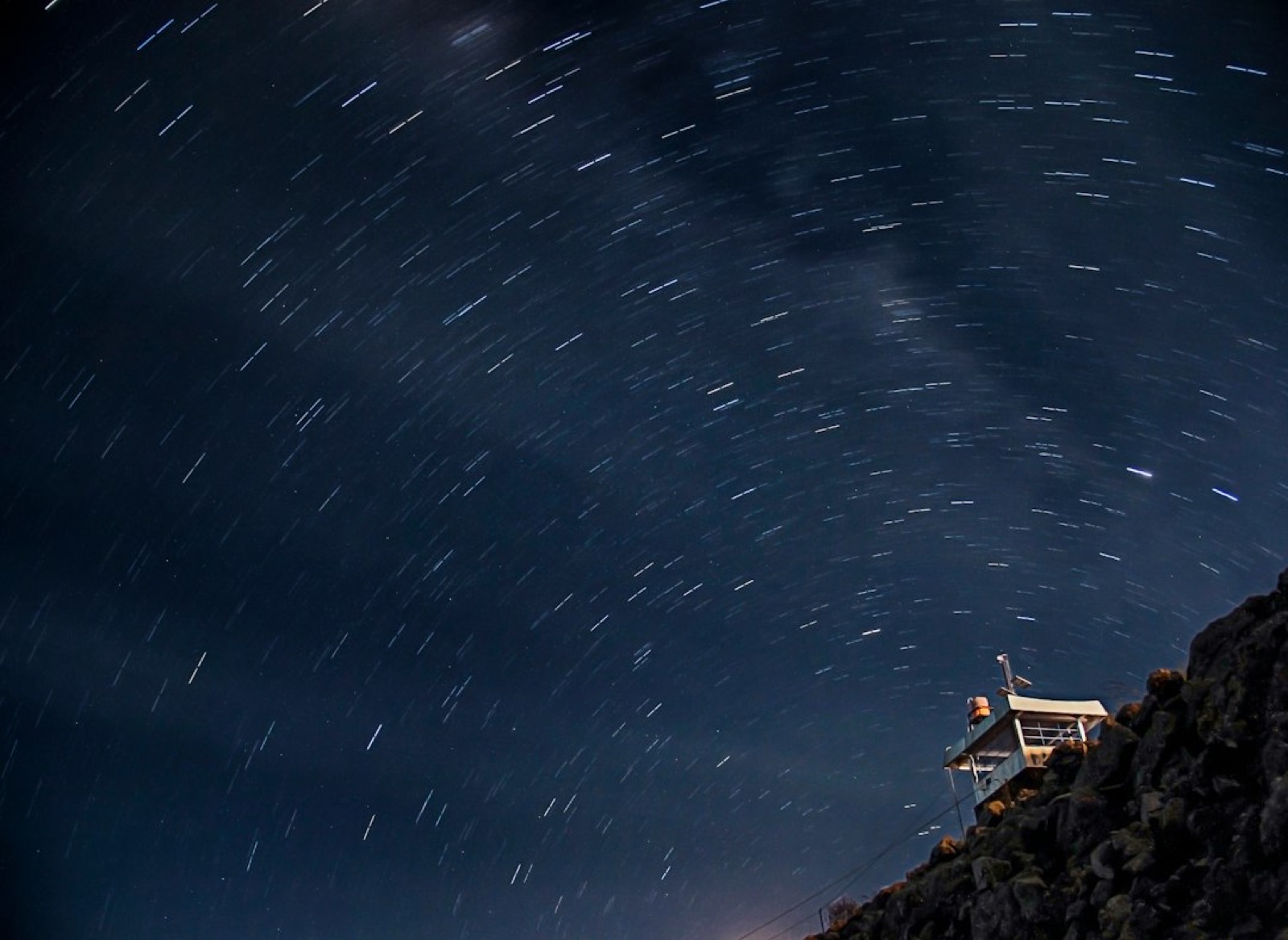 Appareil photo sur trépied pointé vers un ciel étoilé, prêt pour une pose longue de nuit