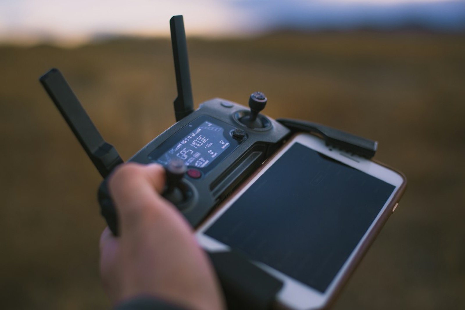 Télépilote tenant la radiocommande d'un drone avant le décollage